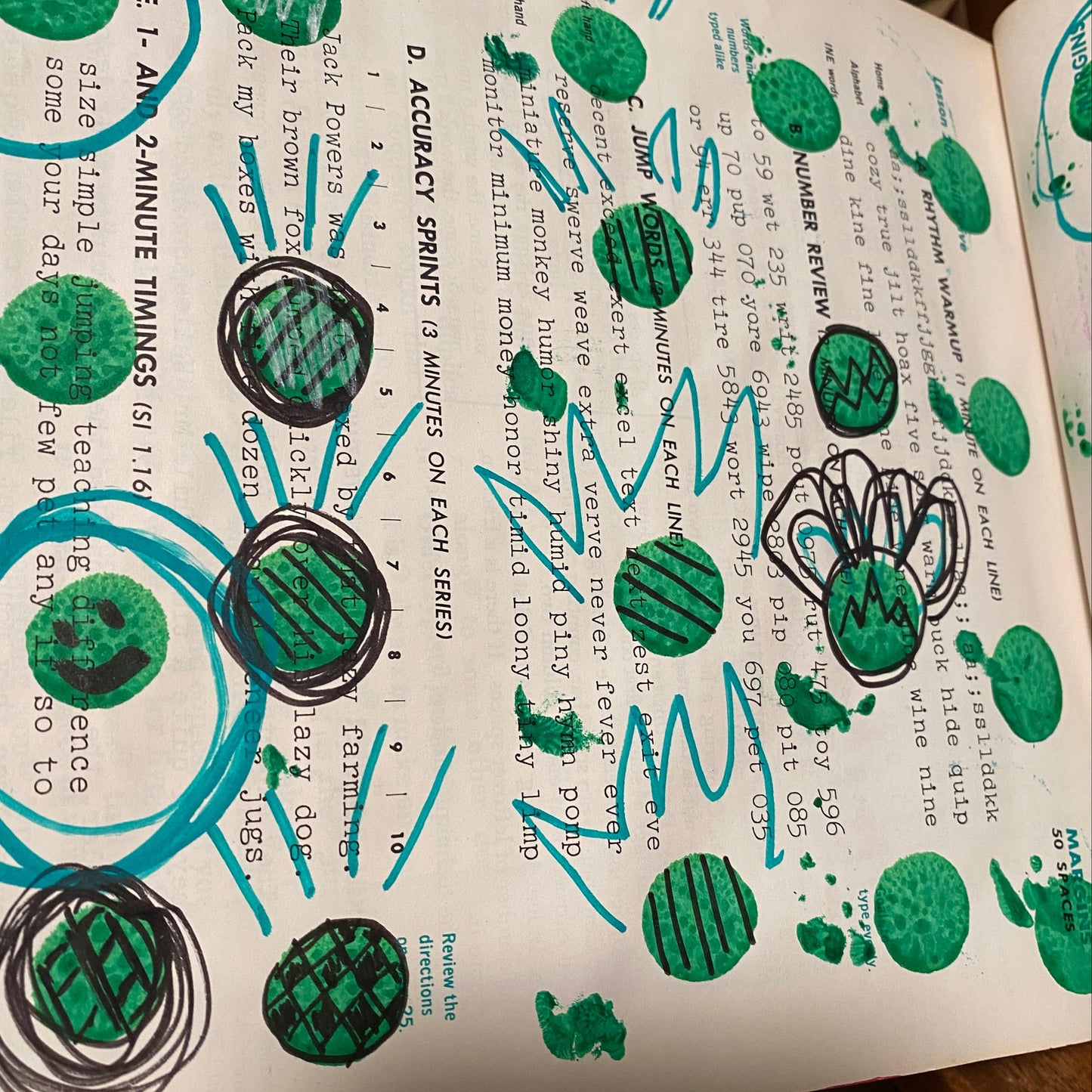 Green circles made with a bingo dauber are scattered over the page. Some are made into faces with a black pen. Others have stripes or checkerboards.