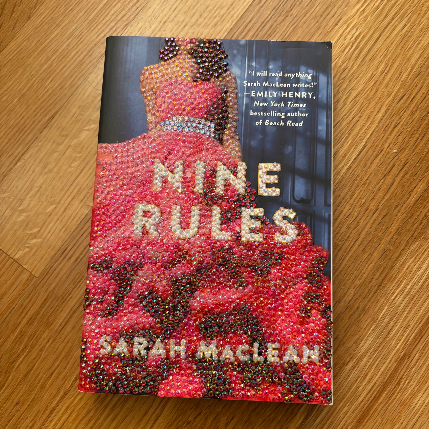 Book titled 'Nine Rules to Break When Romancing a Rake' by Sarah MacLean on a wooden surface