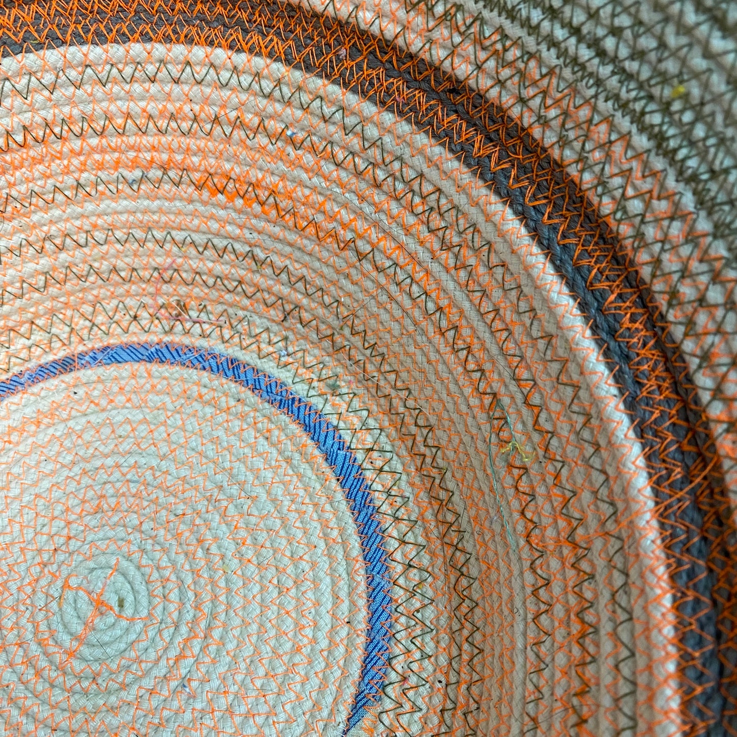 An example of a machine sewn rope bowl. This is a natural color rope bowl with neon orange thread & olive green thread. Some fabric scraps are also used for contrast.