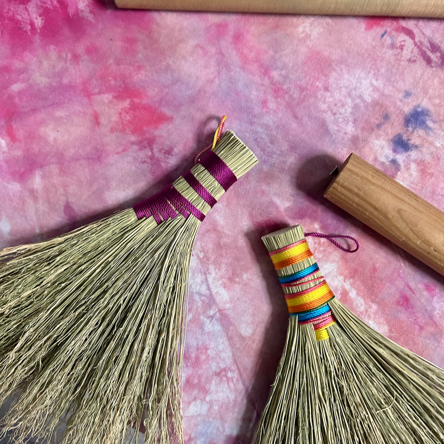 Hand broom examples - one with magenta detail and another with pink, yellow and teal detail