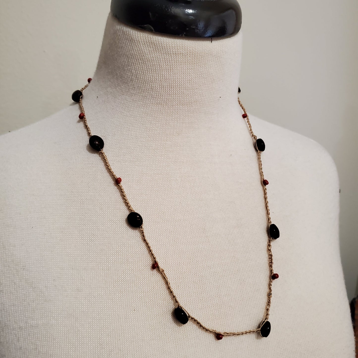 Example of a beaded crochet necklace on a white cloth mannequin.