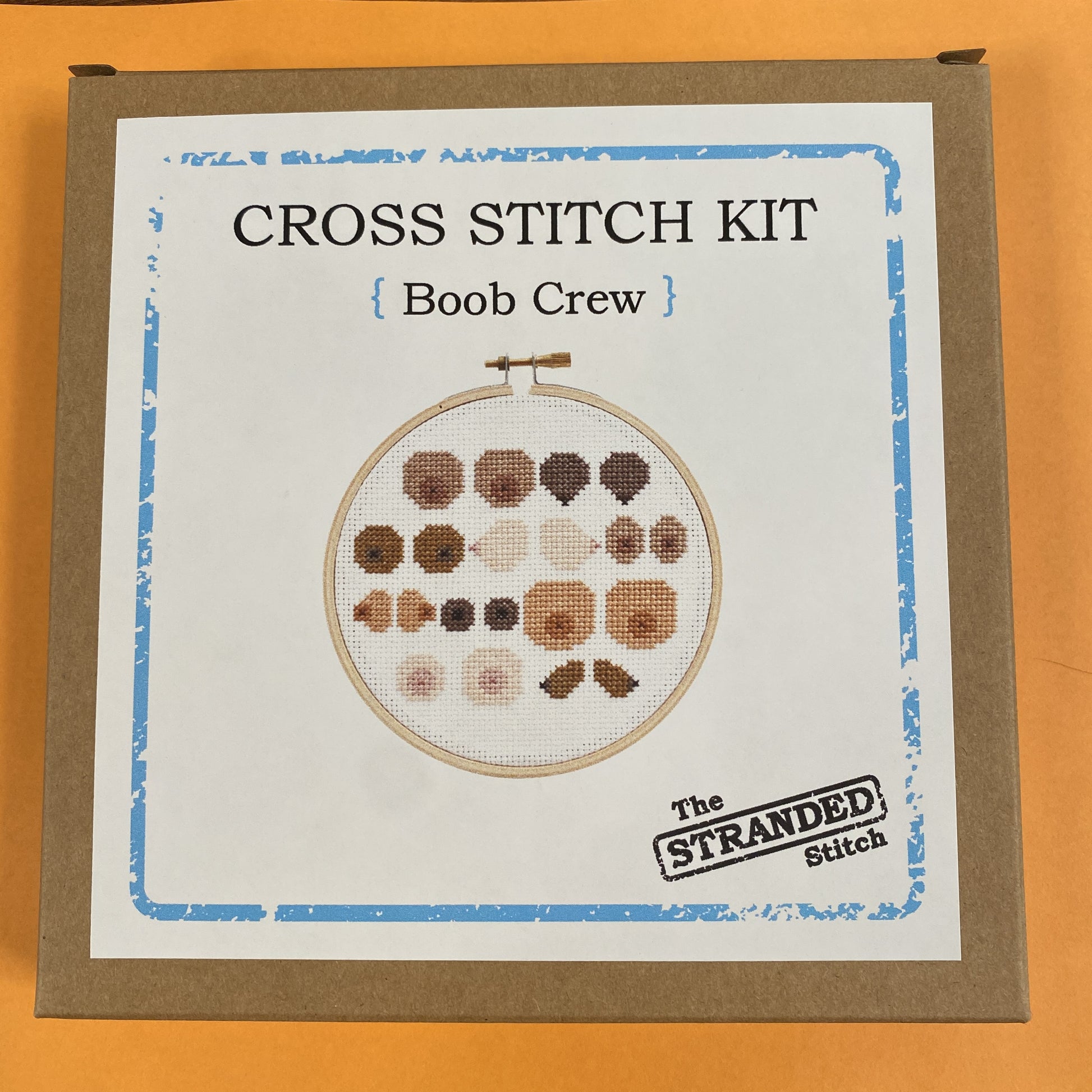 Brown kraft box with a photo of the Boob Crew design on the front.