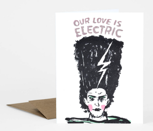 This greeting card is letterpress. It says "Our love is electric" and has a bride of frankenstein on the front.