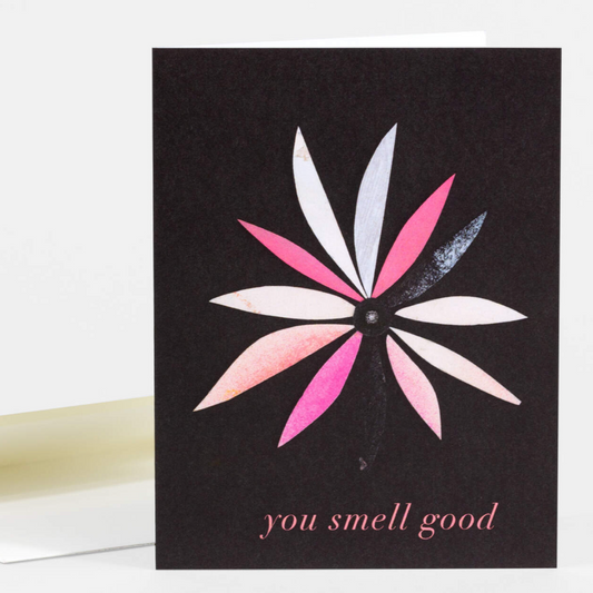 Greeting card with black background and a single flower with different colored petals. It says "You smell good" on the bottom.