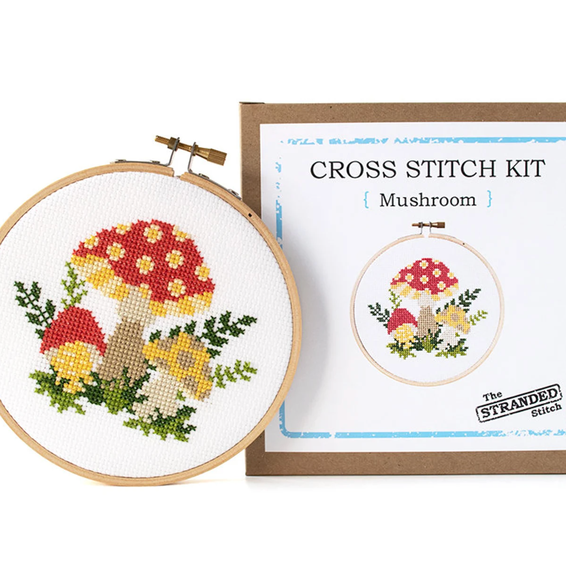 A mushroom cross stitch project completed  - sitting next to a box that the project came in.
