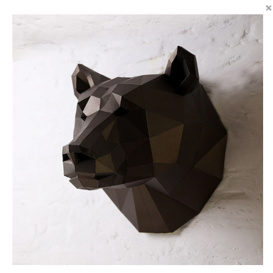 An example of a completed paper craft bear kit hanging on a texture white wall.