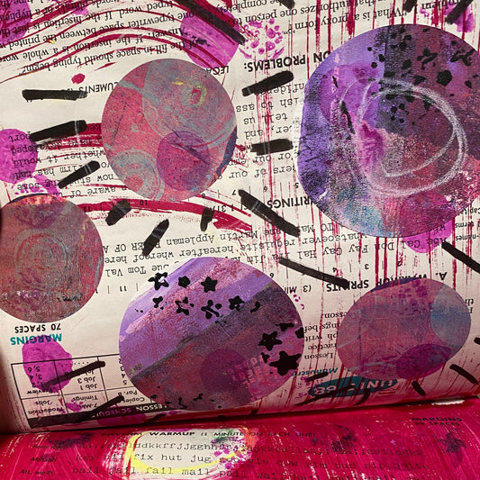 Perfect circles in purple and pink mimic planets. Some are highlighted with black marks radiating from the middle. Others have black stars printed on them. 