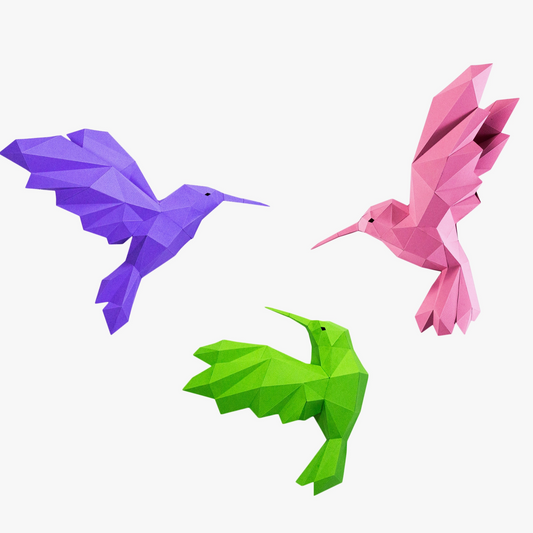 Three examples of paper craft hummingbird kits. They are pink, purple and green - and come in different configurations.