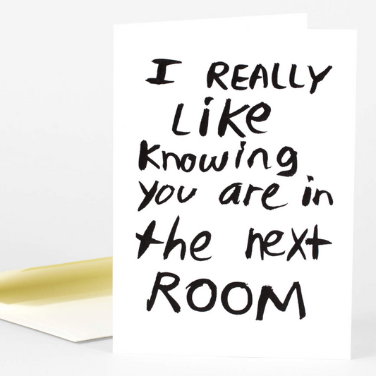 This card is white with large black handwritten lettering. It says, "I really like knowing you are in the next room."
