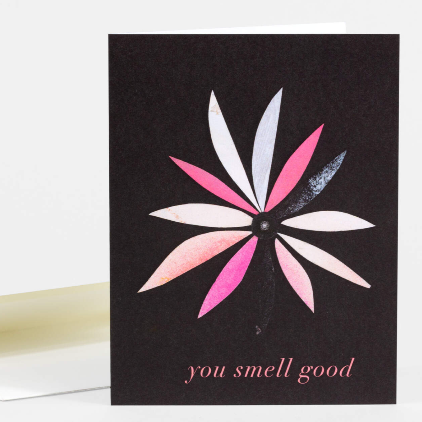 Greeting card with black background and a single flower with different colored petals. It says "You smell good" on the bottom. 