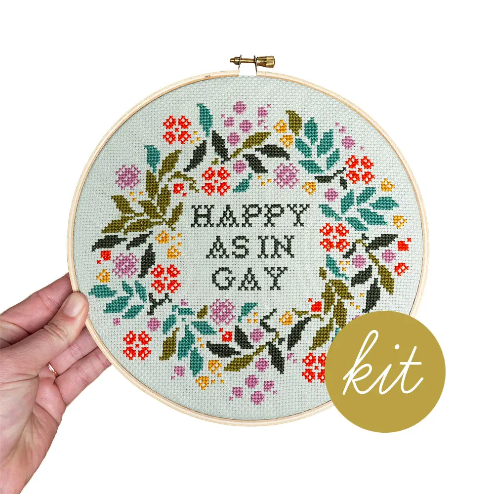 A stitched up example of the "Happy as in Gay" cross stitch kit by Junebug and Darlin.