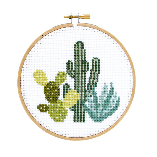 Cross-stitched cacti design in a wooden hoop on a white background