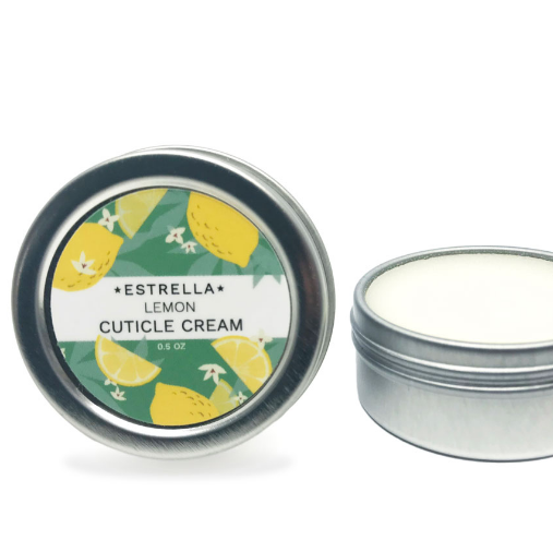 A tin of lemon cuticle cream by Estrella sits on a white background. The lid stands up next to the tin. 