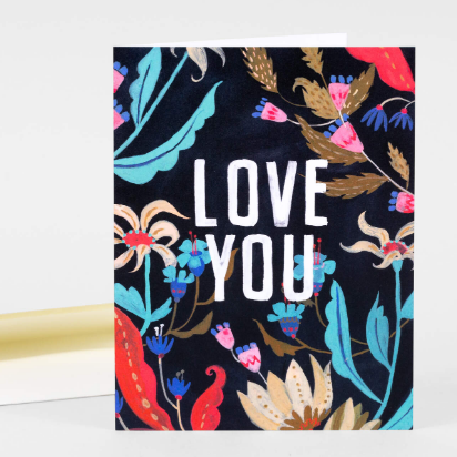 This greeting card has a black background with colorful florals. It says "Love you" in the middle in white letters. 